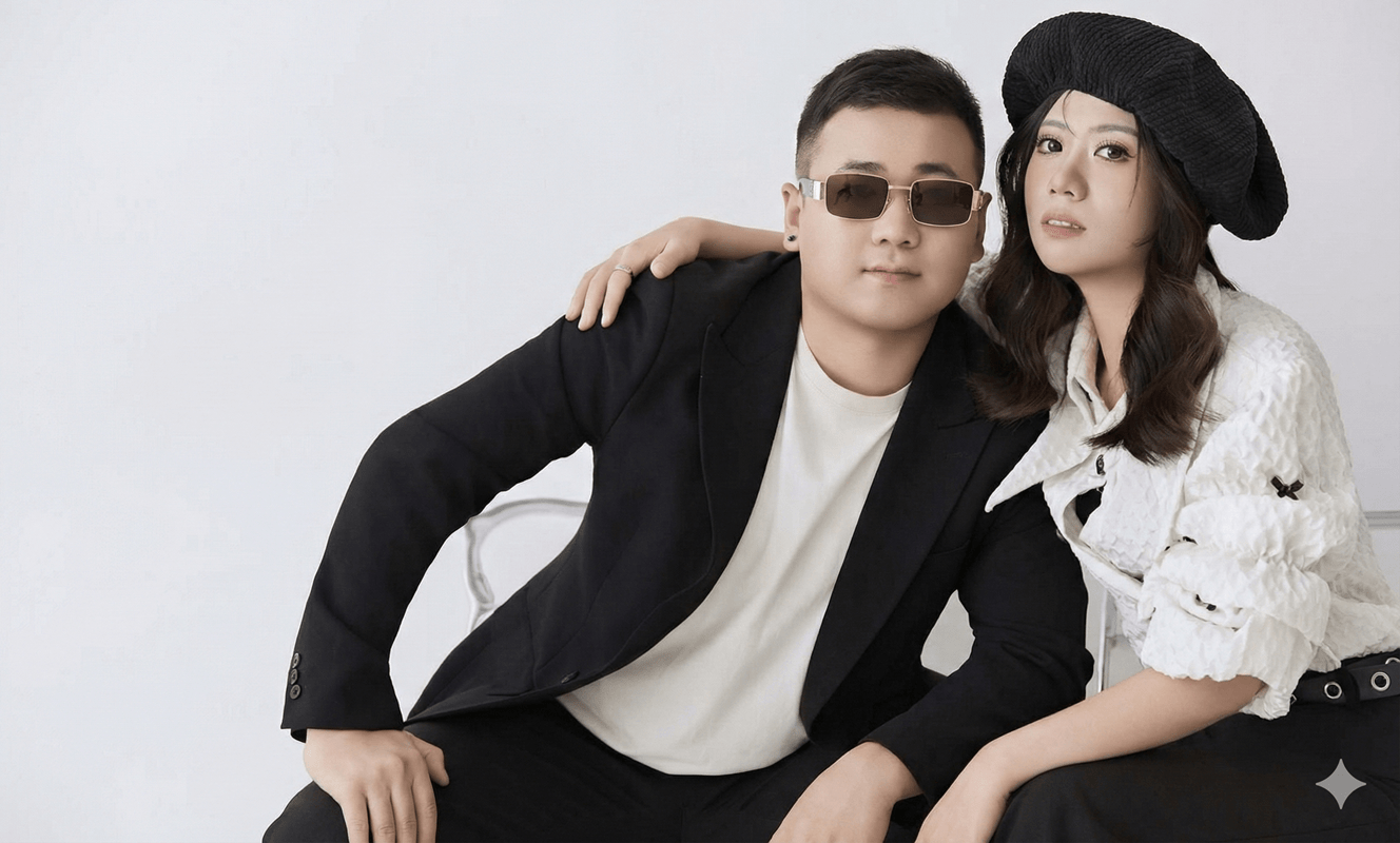 这是一张充满现代感的双人写真（可能为休闲风婚纱照）。男士身着黑色西装搭配白色内搭，佩戴墨镜，气质酷帅；女士头戴黑色贝雷帽，身穿白色纹理上衣，姿态亲密。画面以经典的黑白配色为主，背景简洁，整体风格时尚大方，展现了独特的个性魅力。